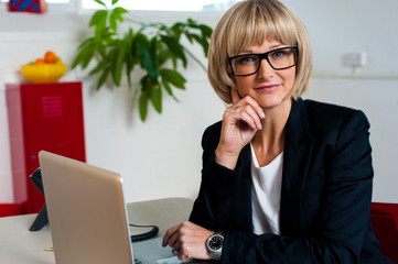 Thoughtful business lady seated in office