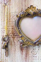 Vintage frame with hanging keys on a wooden background