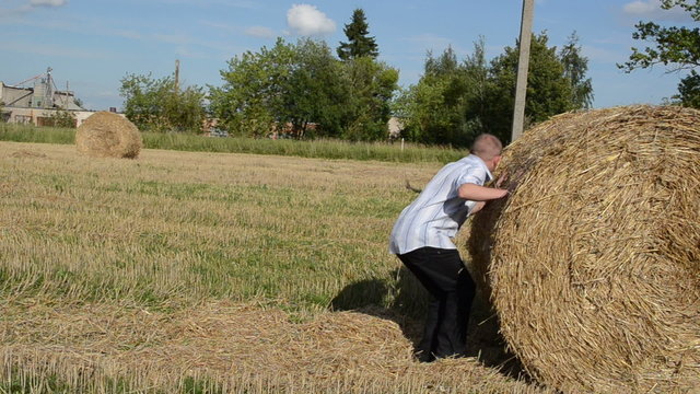man run strike hit fall down round straw bale agriculture field