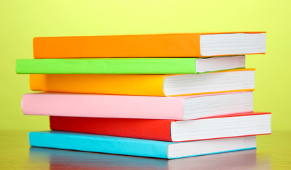 Stack of multicolor books   on green background