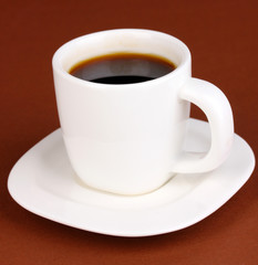A cup of strong coffee on brown background