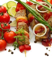 tasty grilled meat and vegetables on skewers, isolated on white