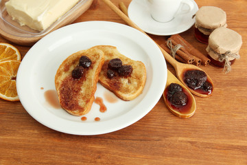 White bread toast with jam and cup of coffee on wooden table