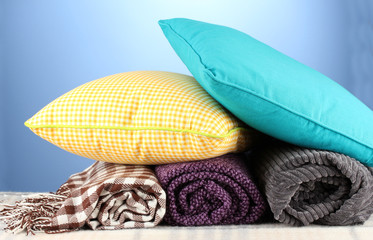 Plaids and color pillows on blue background