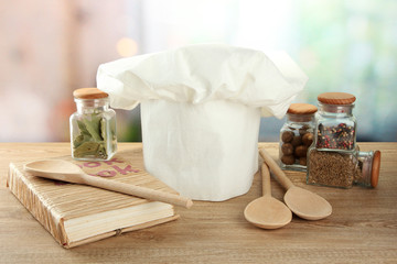 Chef's hat with spoons on table in kitchen