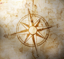 Old compass on paper background