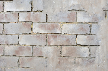Brick wall with peeling plaster