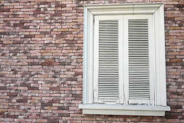 white closed window in brick wall