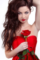 Portrait of beautiful brunette woman holding red rose