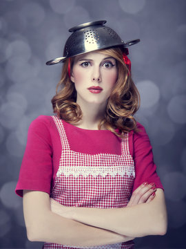 Redhead housewife with colander over head