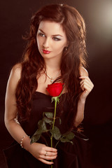 Portrait of beautiful brunette woman with red rose