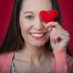 beautiful young woman holding red heart