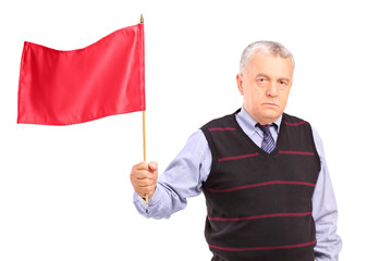 A sad senior man waving a red flag
