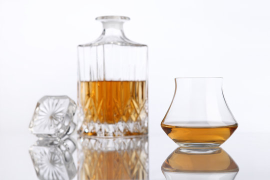 bottle and glass of brandy on a white background