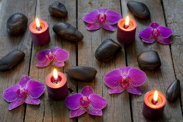 Spa stones orchids and candle on wooden boards