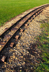 Naklejka premium old rusty railtracks through a meadow