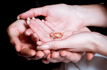Newly wed bride and groom holding hands rings