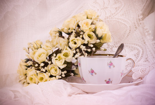 Beautiful flowers in a glass teacup on background