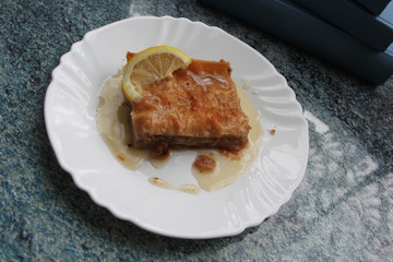 Piece of turkish dessert (baklava) on blue table