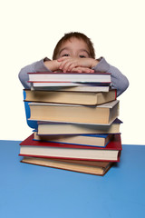 a little boy sitting at a table with books