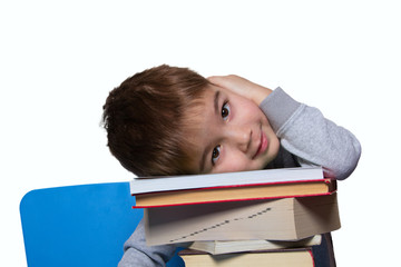 a little boy sitting at a table with books