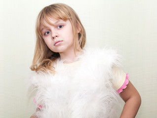 Little blond girl wears white fluffy fur vest