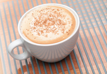 Cappuccino coffee with spice in a white cup