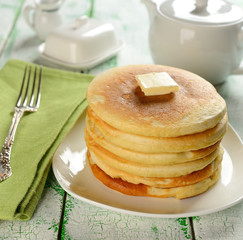 Pancakes with butter on a white table