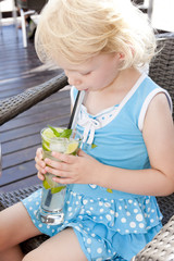 portrait of little girl with a glass of cocktail