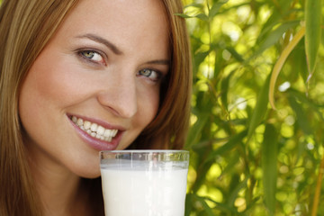 Nahaufnahme einer jungen Frau mit einem Glas Milch