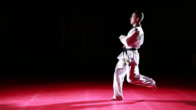 Young taekwondo athlete performing different kicks on black background