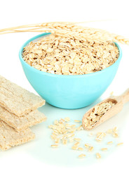 Blue bowl full of oat flakes with wooden scoop, spikelets and