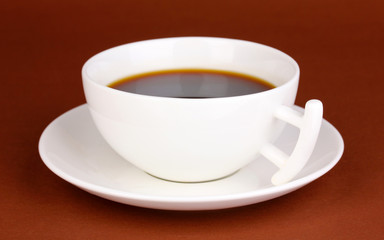 A cup of strong coffee on brown background