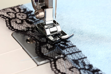 Closeup of sewing machine working part with  blue cloth