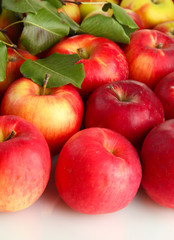 juicy red apples with green leaves, isolated on white