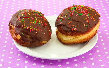 Tasty donuts on color plate on color background