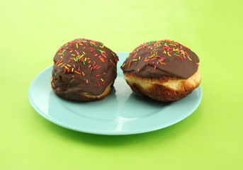 Tasty donuts on color plate on color background