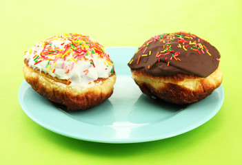 Tasty donuts on color plate on color background