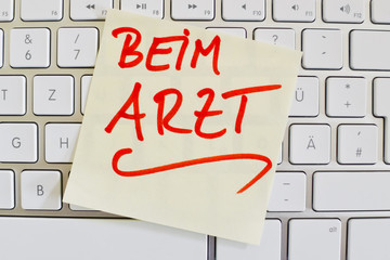 Notiz auf Computer Tastatur: Beim Arzt