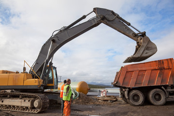 Excavator bucket on a dump truck lifted