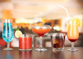 Several glasses of different drinks on bright background