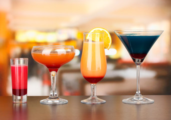 Several glasses of different drinks on bright background