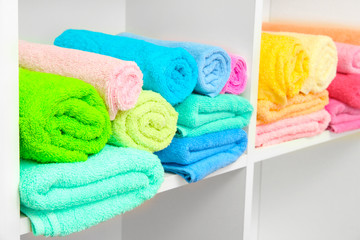 Obraz na płótnie Canvas colorful towels on shelves in bathroom