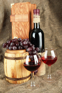 composition of wine,box and grapes on wooden barrel on