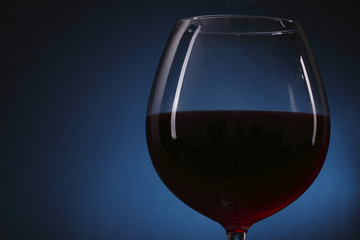 Red wine glass on the blue background