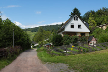 Small road with houses in hilly country