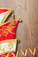 Holzbrett mit bunten Luftschlangen und Karnevalsm&uuml;tze