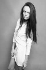 Fototapeta premium Studio shot of amazing woman in white dress looking confident an