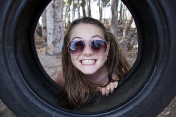 young girl playing with tyre swing