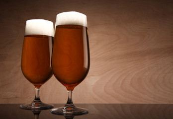Two glasses with beer served on the table
